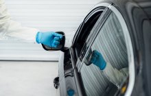 Біолог з захисними рукавичками, що проводять тест на коронавірус на людину в машині — стокове фото