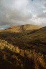 Ruvida collina erbosa nella campagna del Regno Unito in una giornata nuvolosa — Foto stock