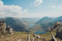 Pintoresco paisaje de estanques azules rodeados de montañas rocosas en un día soleado en Gales - foto de stock