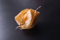 From above of exotic orange Peruvian groundcherry placed on black table in studio — Stock Photo