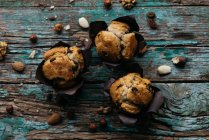 Vista de perto de cima de três muffins caseiros com chocolate e nozes — Fotografia de Stock