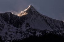 Montanhas rochosas do Himalaia cobertas de neve iluminada pela luz solar brilhante no Nepal — Fotografia de Stock