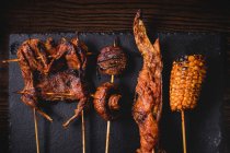 From above composition of tasty grilled skewers with meat, fish, squid and broccoli in cafe — Stock Photo