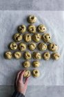 De cima da mão de colheita de massa de farinha fresca de rolamento feminina irreconhecível de massa na cozinha acolhedora — Fotografia de Stock
