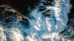 Drone vista di sfondo astratto di onde marine schiumose di colore turchese rotolamento sulla riva del mare — Foto stock