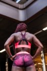 Visão traseira da mulher muscular esportiva étnica com tranças em pé na rua — Fotografia de Stock
