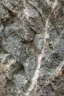 Vue de dessus du fond rugueux texturé de pierre minérale naturelle avec une surface inégale — Photo de stock