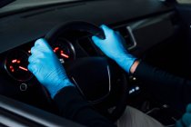 Side view of cropped unrecognizable man using a protective mask driving car during quarantine time — Stock Photo