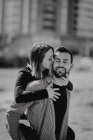 Barbudo hombre abrazando a la mujer, mientras que pasar tiempo en el césped verde en la calle juntos - foto de stock