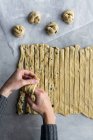De cima da mão de colheita de massa de farinha fresca de rolamento feminina irreconhecível de massa na cozinha acolhedora — Fotografia de Stock