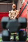 Von unten starker Sportler beim Seilziehen mit schweren Gewichten beim intensiven Training im modernen Fitnessstudio — Stockfoto