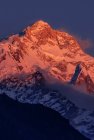Montagne rocciose dell'Himalaya coperte di neve illuminate dalla luce del tramonto arancione in Nepal — Foto stock