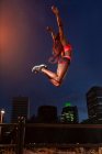 Ethnic athlete jumping on street — Stock Photo