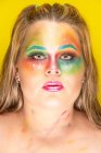 Plus Size-Weibchen mit leuchtend buntem Make-up vor gelbem Hintergrund — Stockfoto