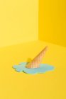 Mockup blue melting ice cream in waffle cone placed on yellow background representing summer concept — Stock Photo