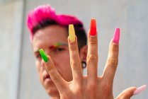 Confident gay male with long colorful nails looking at camera in street on sunny day — Stock Photo