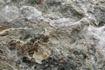 Vue de dessus du fond rugueux texturé de pierre minérale naturelle avec une surface inégale — Photo de stock