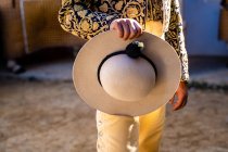 Crop unrecognizable bullfighter in traditional costume decorated with embroidery holding a hat preparing for corrida festival — Stock Photo
