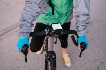 De courrier anonyme ci-dessus examinant itinéraire sur la carte GPS avant d'équitation vélo sur la rue de la ville — Photo de stock