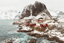 From above aerial view cabins located on mountain range snowy coast on Lofoten Islands, Norway — Stock Photo