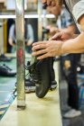 Detalhe das mãos do homem ao verificar os sapatos na linha de produção de controle de qualidade na fábrica de sapatos chineses — Fotografia de Stock