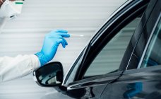 Биолог в защитных перчатках проводит коронавирусный тест человека в машине — стоковое фото
