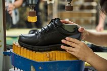 Деталь жіночих рук при перевірці взуття в лінійці контролю якості виробництва на китайському взуттєвому заводі — стокове фото
