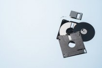 Angle élevé de pièces de disquette à l'ancienne disposées sur fond bleu — Photo de stock