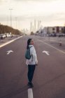 Vista posteriore della donna viaggiatrice che cammina lungo un viale con Dubai Marina sullo sfondo — Foto stock