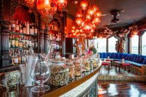 Interior de pub acolhedor com lâmpadas iluminadas e balcão de madeira com decorações variadas — Fotografia de Stock