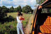 Fotografo donna in viaggio felice scattare foto sulla macchina fotografica professionale durante le vacanze nel bosco — Foto stock