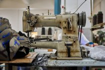 Detalhe da velha máquina de costura em uma fábrica de sapatos chineses ocupados — Fotografia de Stock
