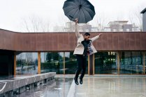 Ritratto di elegante uomo nero con cappotto grigio e ombrello per strada — Foto stock