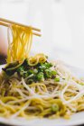 Appetitlich leckere heiße Sojadudeln auf weißem Teller mit Holzstäbchen im asiatischen Restaurant — Stockfoto