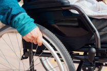 Ritagliato donna anziana irriconoscibile in sedia a rotelle lungo argine vicino al mare e godersi la giornata estiva — Foto stock