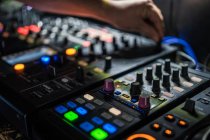 De cima homem colheita jogando profissional controlador de DJ de dois canais durante a realização em concerto no clube noturno moderno — Fotografia de Stock