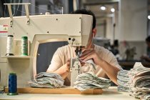 Detalhe das mãos dos trabalhadores fazendo costura no couro dos sapatos na fábrica de sapatos chineses — Fotografia de Stock