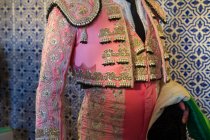 Crop unrecognizable male toreador in traditional costume decorated with embroidery preparing for corrida festival — Stock Photo