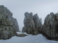 Montagne rocciose coperte di foschia e neve contro il cielo nuvoloso in inverno nel Parco Nazionale di Guadarrama a Madird, Spagna — Foto stock