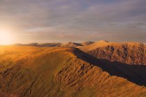 Cenário espetacular do céu brilhante da noite do por do sol sobre a escala da montanha em Wales — Fotografia de Stock