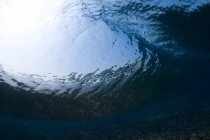 Подводный вид грубого каменистого дна моря с голубой водой в дневное время — стоковое фото