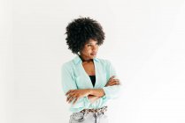 Felice giovane donna afro-americana con bei capelli afro in abito alla moda guardando lontano su sfondo bianco — Foto stock