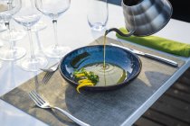 Waiter pouring lentil soup at outdoor high cuisine restaurant — Stock Photo
