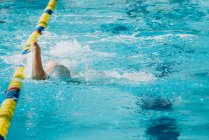 Seitenansicht des paralympischen Sportlers in Brille und Mütze ohne Handschwimmstil im Pool zwischen den Bahnen — Stockfoto