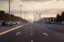 Avenida vazia ao pôr do sol em direção à Marina do Dubai com edifícios ao fundo — Fotografia de Stock