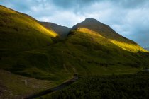 Overcast sundown sky over hill slope and curvy river in peaceful evening in Glen Etive, United Kingdom — Stock Photo