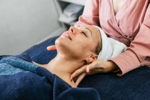 Обрізані невпізнавані масажистські плечі жіночого клієнта лежать на столі в салоні краси — стокове фото