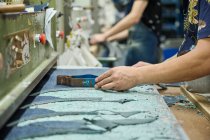 Dettaglio dell'uso operaio del modello di taglio durante il taglio del tessuto nella fabbrica di scarpe cinesi — Foto stock