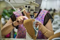 Деталь рабочих рук, делающих шитье в коже обуви на фабрике китайской обуви — стоковое фото