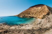 Paisagem pitoresca de praia de areia e mar azul em terras altas no dia ensolarado no verão — Fotografia de Stock